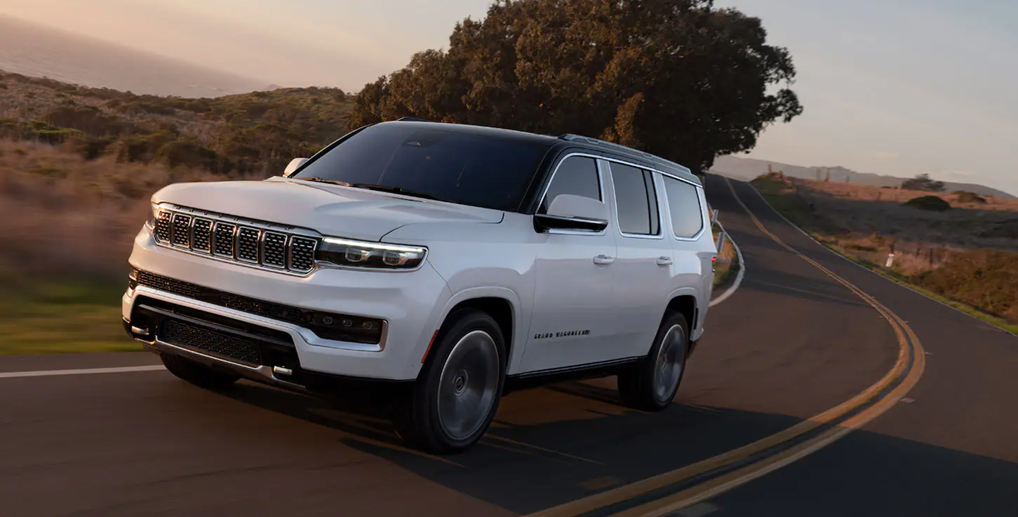 A new Jeep Grand Wagoneer driving on a turn.