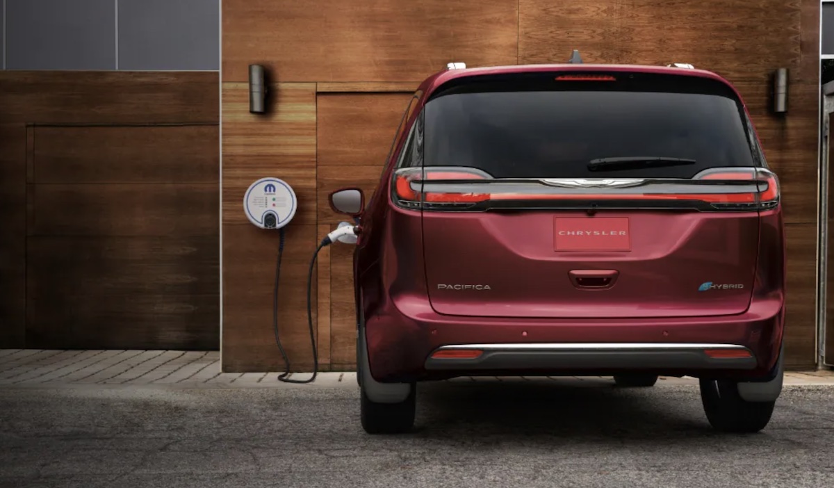 Red 2023 Chrysler Pacifica Hybrid at charging station