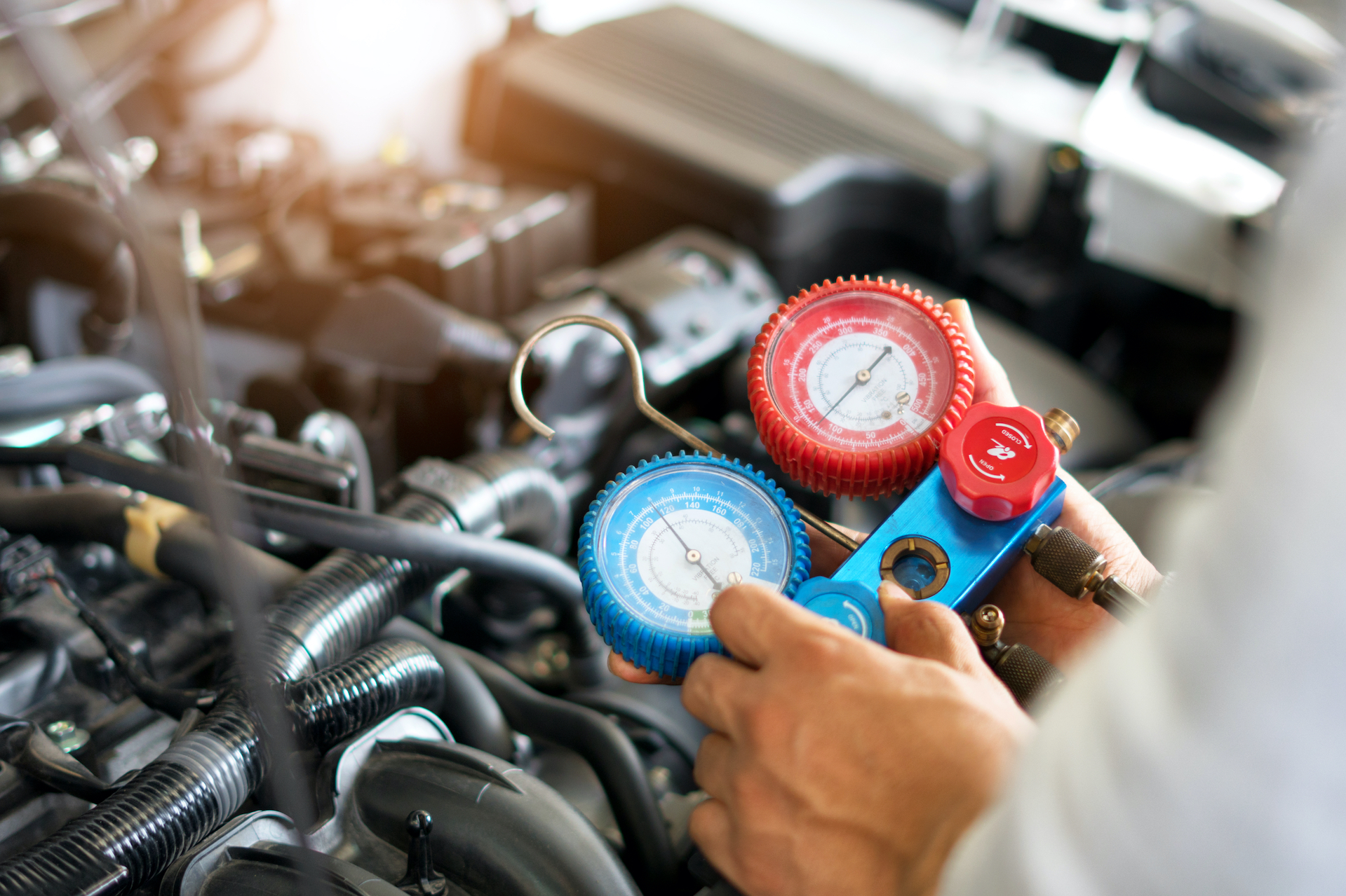 Technician performing a/c service on vehicle