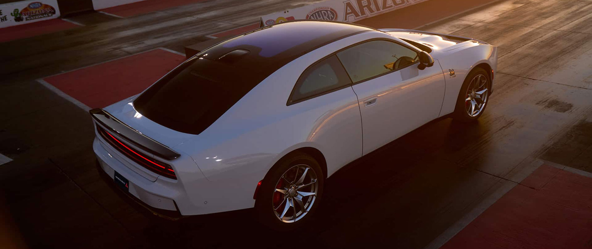 A white Dodge Charger on a race track.