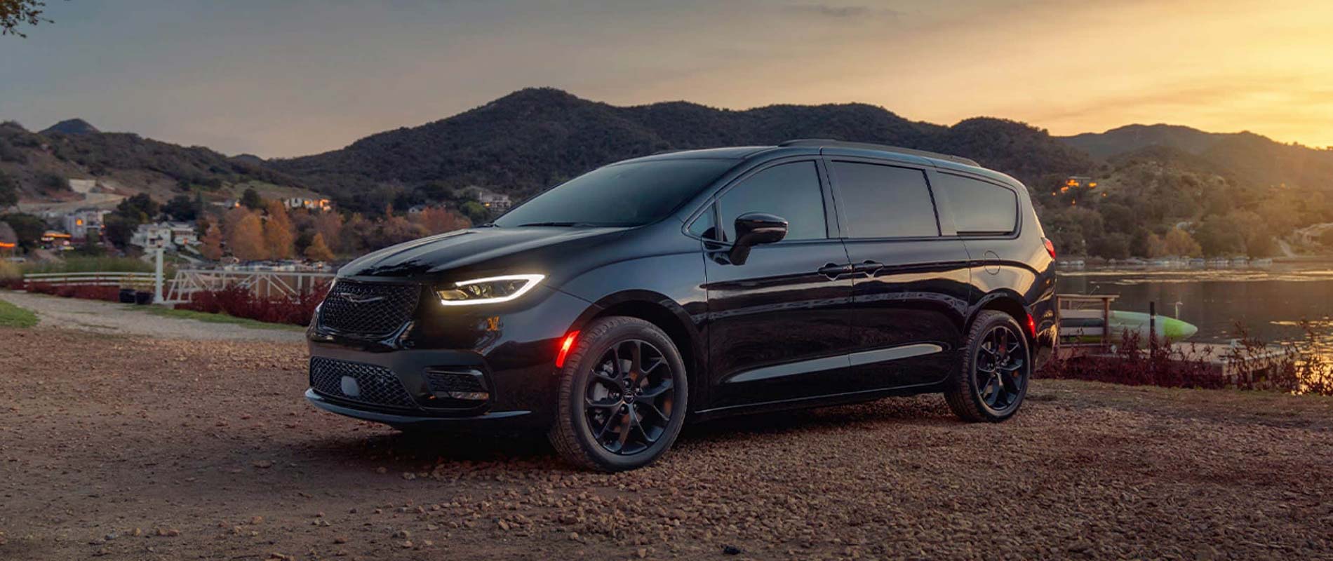 A black Chrysler Pacifica parked by a lake.