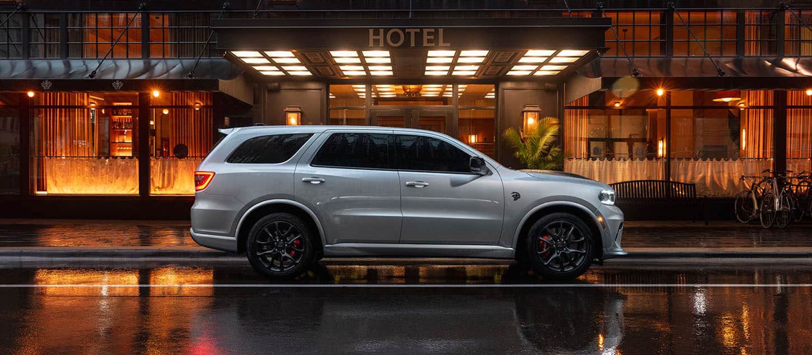 A silver 2026 Dodge Durango in profile, parked in front of a hotel.