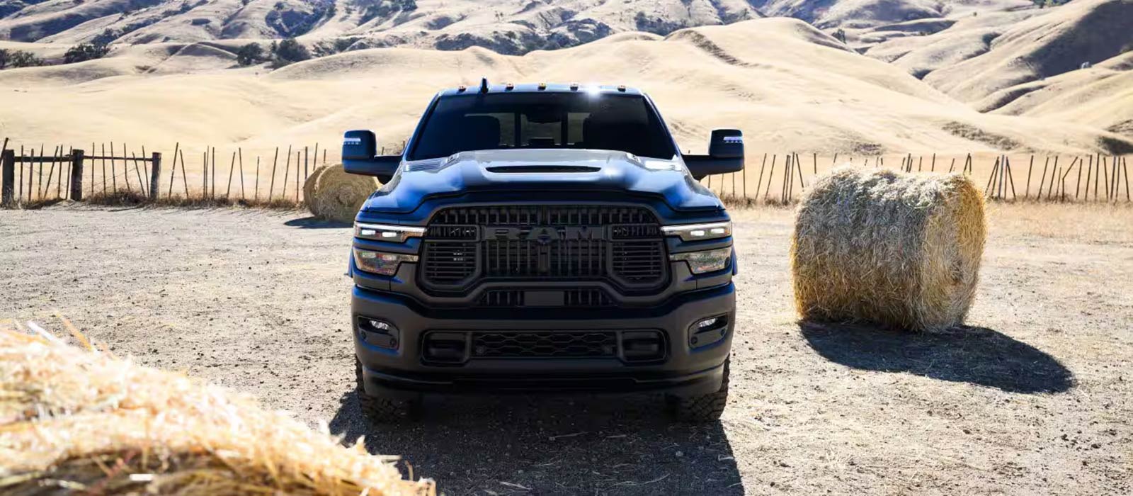 A front view of a blue 2026 RAM 2500 on a farm.