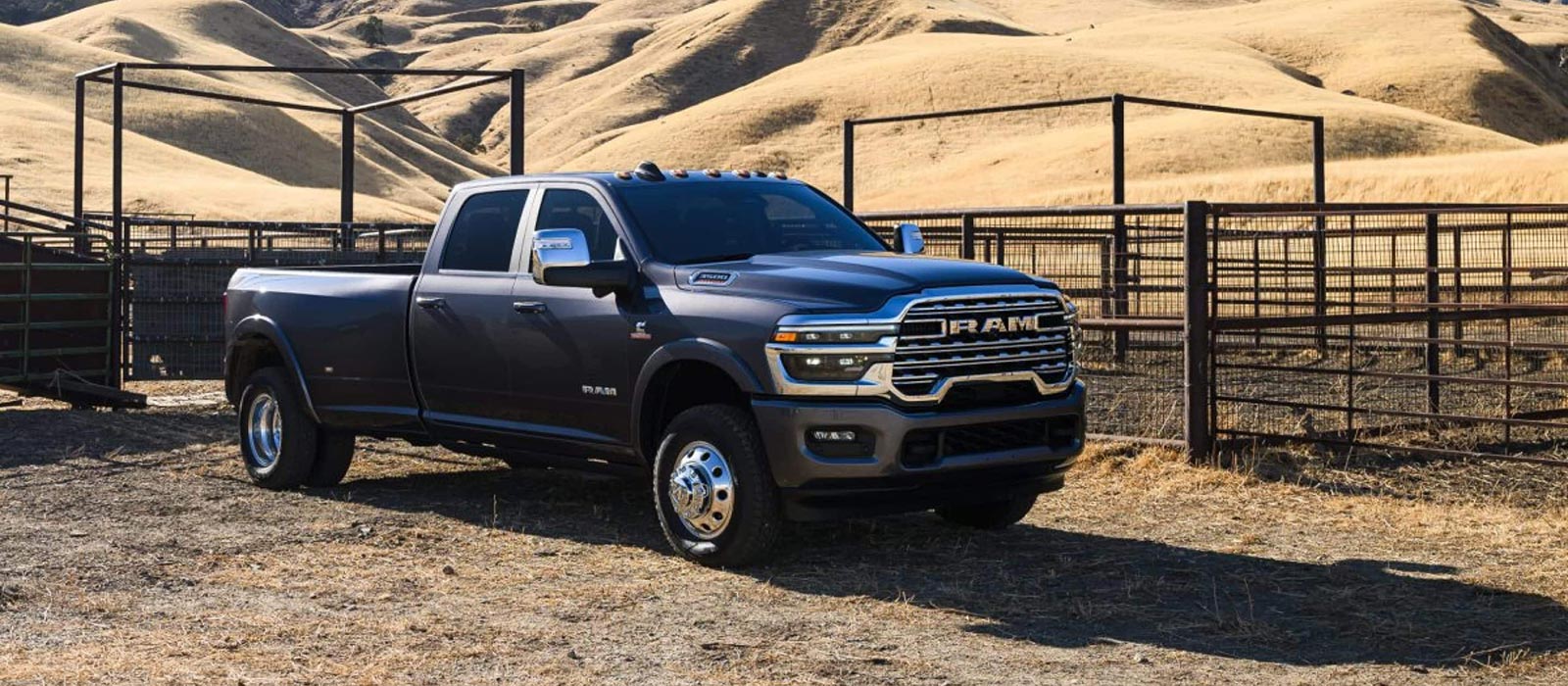 A navy blue RAM 3500 parked on a ranch in a desert.