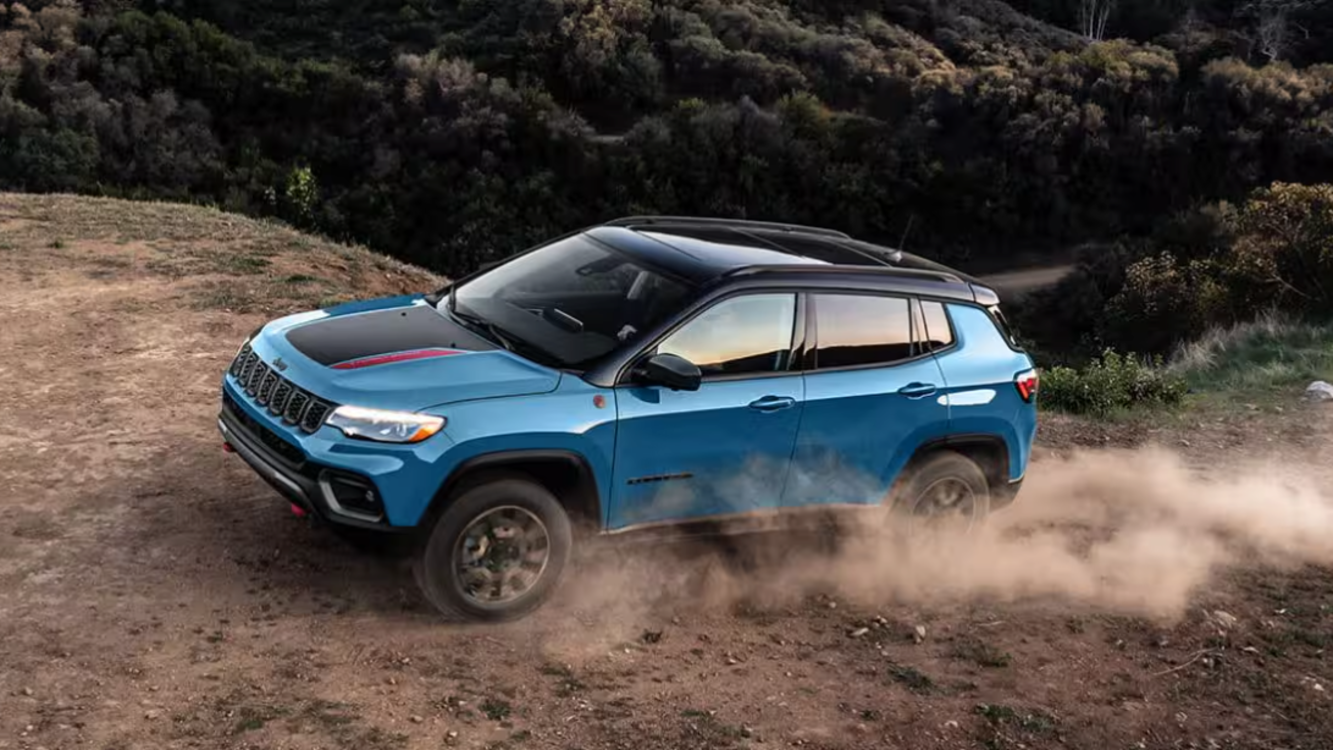 2026 Jeep Compass on a dirt road with dust surrounding the wheels