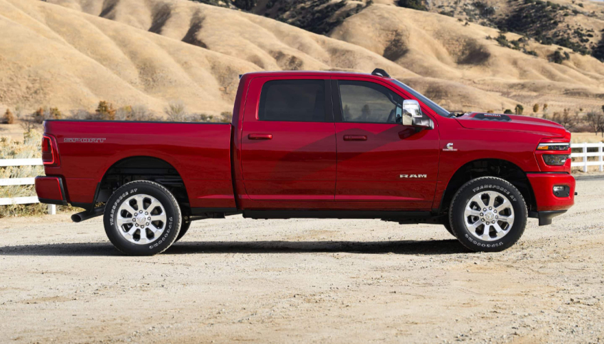 A red RAM 2500 in profile on a ranch in the desert.